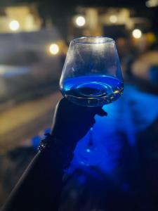 a person holding up a glass of blue liquid at Happy Villas in Paje