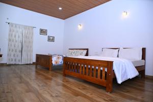 a bedroom with a large bed and a wooden floor at Whispering Meadows By Dazzle Destinations - Coorg in Somvārpet