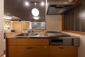 a kitchen with a sink and a microwave at Tsuzumi Suite - Private Cinema & Immersive Stay in Kanazawa in Housai