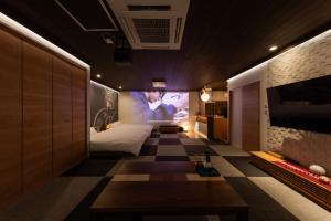 a bedroom with a bed and a tv on a wall at Tsuzumi Suite - Private Cinema & Immersive Stay in Kanazawa in Housai
