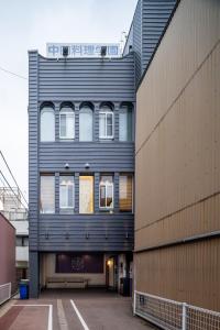 a black building with windows on the side of a building at Tsuzumi Suite - Private Cinema & Immersive Stay in Kanazawa in Housai