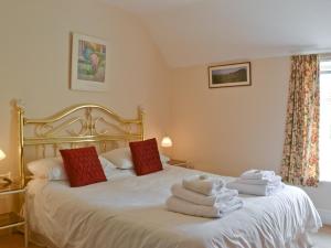 a bedroom with a bed with towels on it at Honeysuckle Cottage in Minsterley