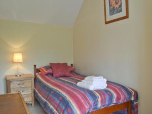 a bedroom with a bed with towels on it at Honeysuckle Cottage in Minsterley