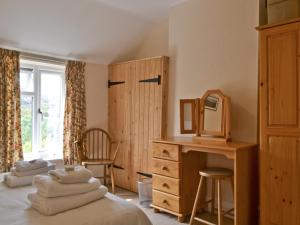a bedroom with two beds and a desk and a mirror at Honeysuckle Cottage in Minsterley +8 photos
