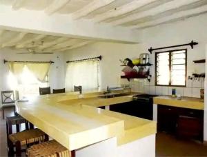a large kitchen with a large wooden counter top at Diani modern Doric Cottages in Msambweni