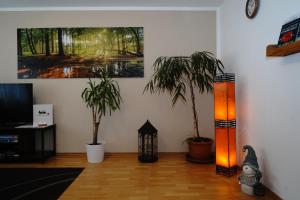 a living room with two potted plants and a lamp at Ferienwohnung Schog in Todtnau