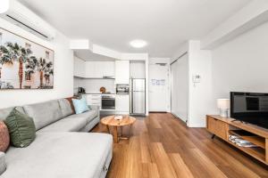 a living room with a couch and a table at Seaside Luxe - L8 - Local Eats, Walks, Swims, CBD in Newcastle +12 photos