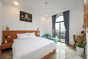 a bedroom with a white bed and a large window at Ly Ly Luxury Hotel in Ho Chi Minh City +95 photos