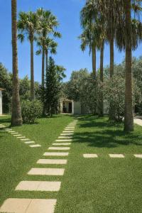 a garden with palm trees and a pathway at Finca Feliciano in Novo Sancti Petri