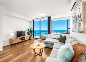 a living room with a couch and a table at Seaside Luxe - L8 - Local Eats, Walks, Swims, CBD in Newcastle