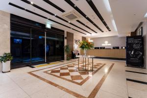 a lobby with a table in the middle of a building at 브라운도트호텔 인천 송도 Browndot Hotel Incheon Songdo in Incheon