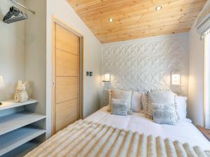 a bedroom with a white bed with a wooden ceiling at Barn Owl Lodge - Uk49903 in Appley Bridge