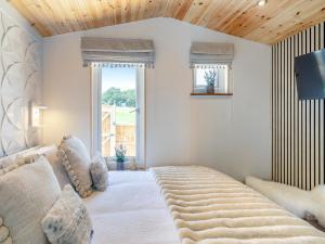 a bedroom with a large bed with a wooden ceiling at Barn Owl Lodge - Uk49903 in Appley Bridge +17 photos