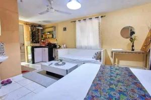 a bedroom with a bed and a living room at Masai Apartments Diani in Ukunda +1 photo