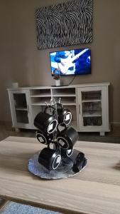 a living room with a table with a television and a vase at Masai Apartments Diani in Ukunda