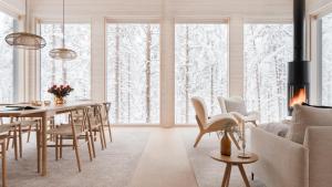 a living room with a dining room table with a fireplace at Arctic Design Villa Levi in Levi