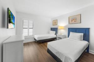a bedroom with two beds and a tv in it at Beach Villas 2514 condo in Captiva