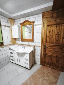 a bathroom with a sink and a mirror and a door at Ferienwohnung Leon in Heldburg +10 photos
