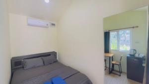 a bedroom with a bed and a desk and a window at Thung Setthi Homestay&Cafe5 in Chiang Dao