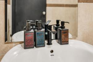 a bathroom sink with four bottles ofodorizers on it at Chill Inn Hub in Lamai