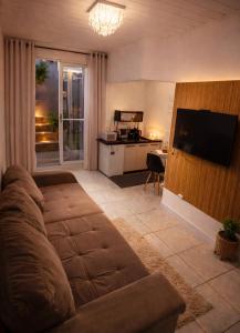 a living room with a couch and a television at Studio Central - Climatizado - Prático in Erval dʼOeste