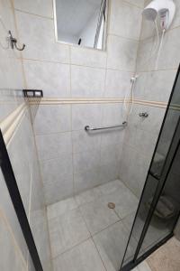 a bathroom with a shower with a glass door at Studio Central - Climatizado - Prático in Erval dʼOeste +8 photos