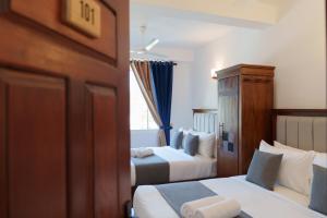 a hotel room with two beds and a window at St Anthonys Holiday Inn in Kotagala +42 photos