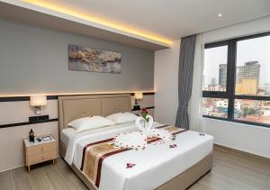 a hotel room with two beds and a window at LN Hotel & Residence in Phnom Penh