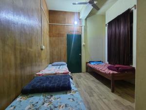 two beds in a room with wooden walls at Mizotel in Āīzawl +7 photos