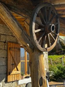 a wooden wagon wheel on display in front of a cabin at appartement de standing avec jacuzzi exterieur in Zonza