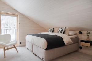 a white bedroom with a bed and a window at Arctic Design Villa Levi in Levi +39 photos