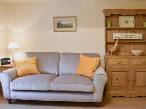 a living room with a gray couch with yellow pillows at Harriet's Hideaway in Braithwaite