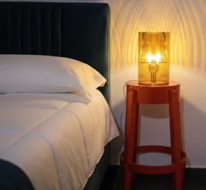 a lamp on a night stand next to a bed at RUDIAE Palace In Lecce in Lecce