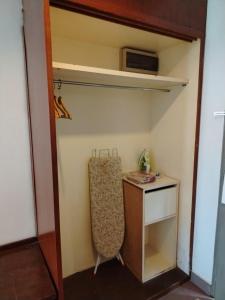 a small room with a desk and a shelf at Hotel Seri Malaysia Port Dickson in Port Dickson