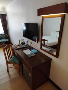 a room with a desk with a mirror and a bed at Hotel Seri Malaysia Port Dickson in Port Dickson