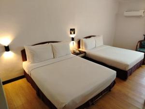 two beds in a hotel room with white sheets at Hotel Seri Malaysia Port Dickson in Port Dickson +62 photos
