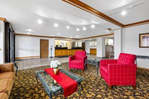 a living room with red chairs and a table at Quality Inn near Monument Health Rapid City Hospital in Rapid City