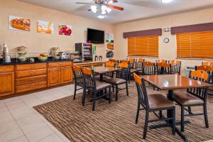 a dining room with tables and chairs and a kitchen at Quality Inn Tomah in Tomah