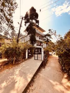 a building with a gate next to a dirt road at Kusum Nest in Shillong +23 photos