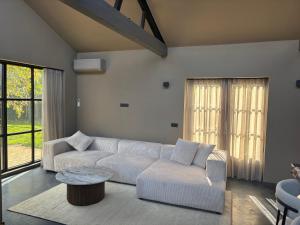 a living room with a white couch and a table at Schuurwoning in Weert