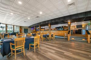 a dining room with blue tables and chairs at Fairway Inn and Suites, an Ascend Collection Hotel in Mishicot