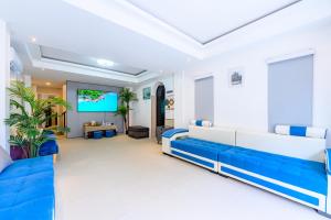 a living room with blue and white furniture and a flat screen tv at Mountain View Escape at Primrose Hill in Bangrak Beach