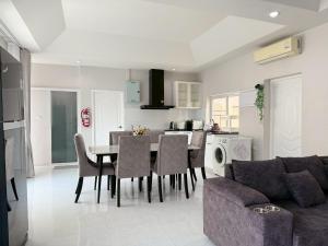 a living room and kitchen with a table and chairs at Buddy pool villa in Nong Prue