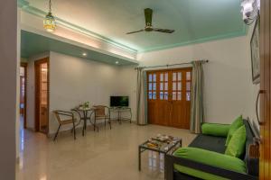 a living room with a green couch and a table at Victor Exotica An Indy Resort in Candolim