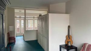 a room with a guitar on the wall and a room with a chair at Studio 11 in Utrecht