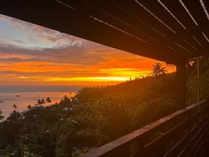 a sunset over the ocean from a house at Matira Hills Apartment in Bora Bora