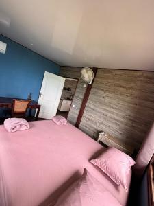 a bedroom with a pink bed with two pink pillows at Matira Hills Apartment in Bora Bora