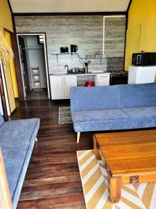 a living room with a blue couch and a kitchen at Matira Hills Apartment in Bora Bora