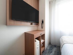 a hotel room with a television on a wall at Vessel Inn Hakata Nakasu in Fukuoka