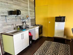 a small kitchen with a sink and a microwave at Matira Hills Apartment in Bora Bora